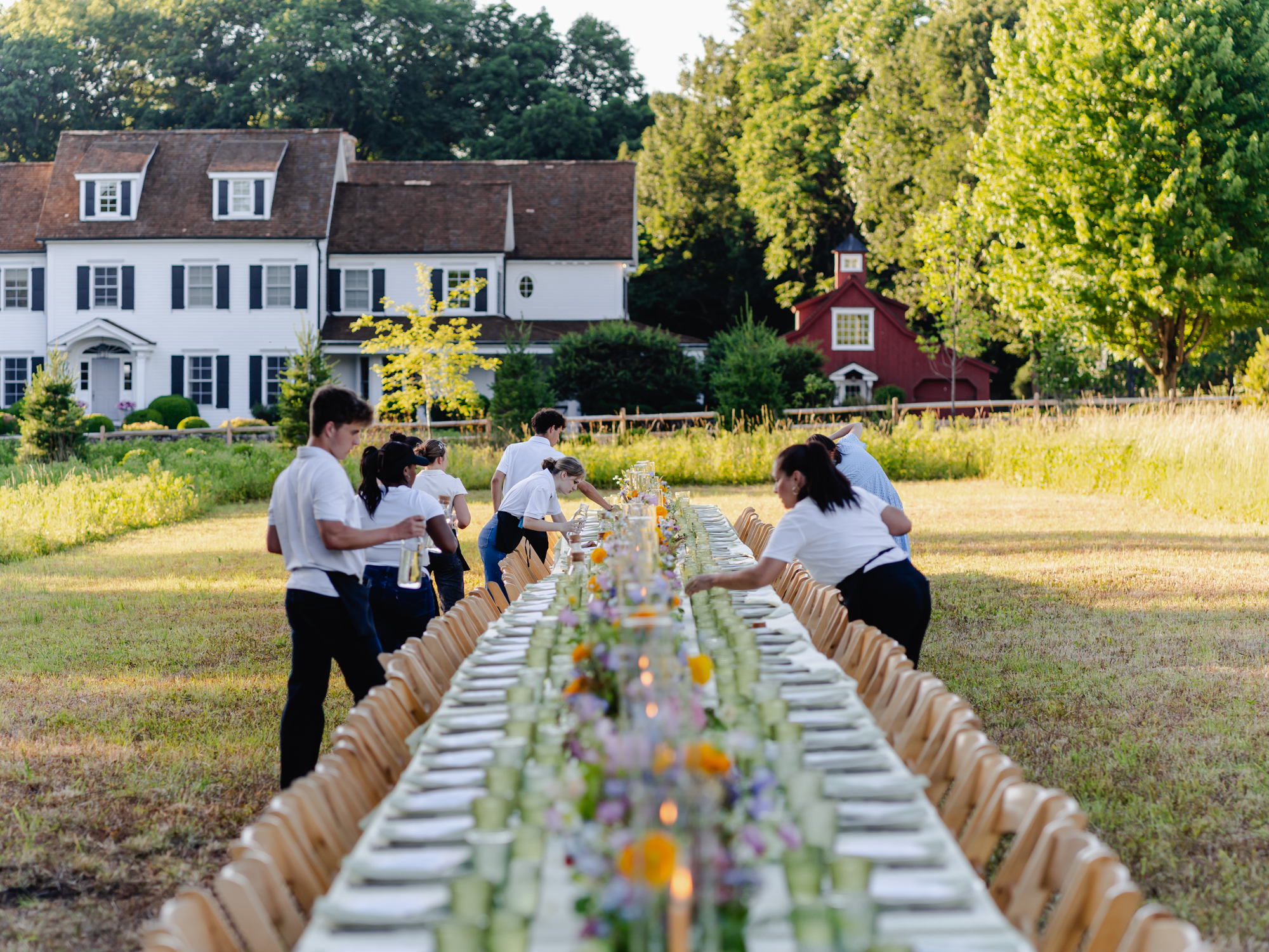 A long farm-table dinner set for an outdoor Simply Greer gathering in Fairfield County.